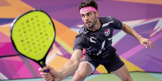 Giocatore di padel in azione sul campo vibrante.